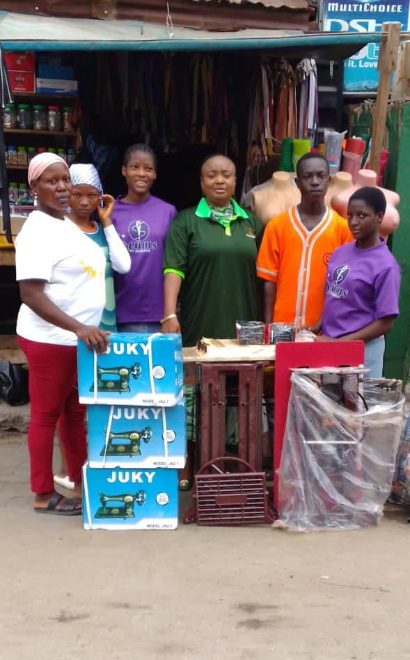 TKA empowerment outreach with sewing machines and trainees.